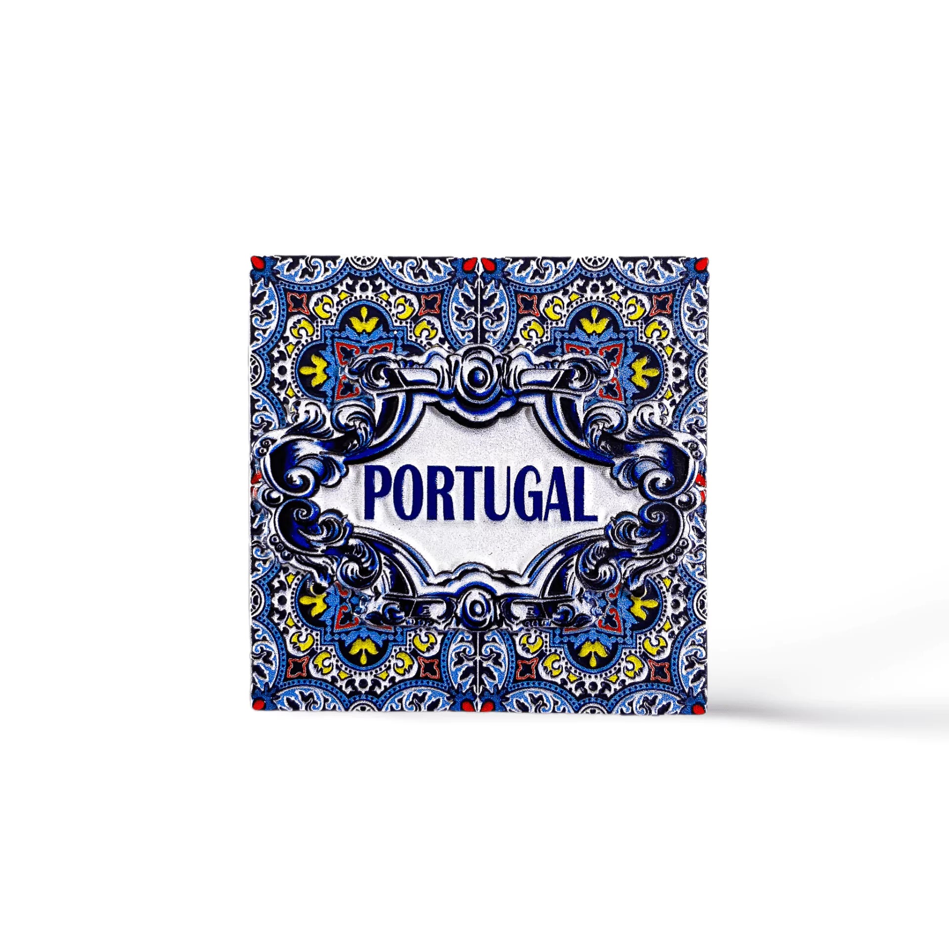 A decorative tile magnet featuring intricate blue, yellow, and white patterns with the word "PORTUGAL" in the center, surrounded by ornate floral and geometric designs. This charming souvenir evokes traditional Portuguese azulejos.