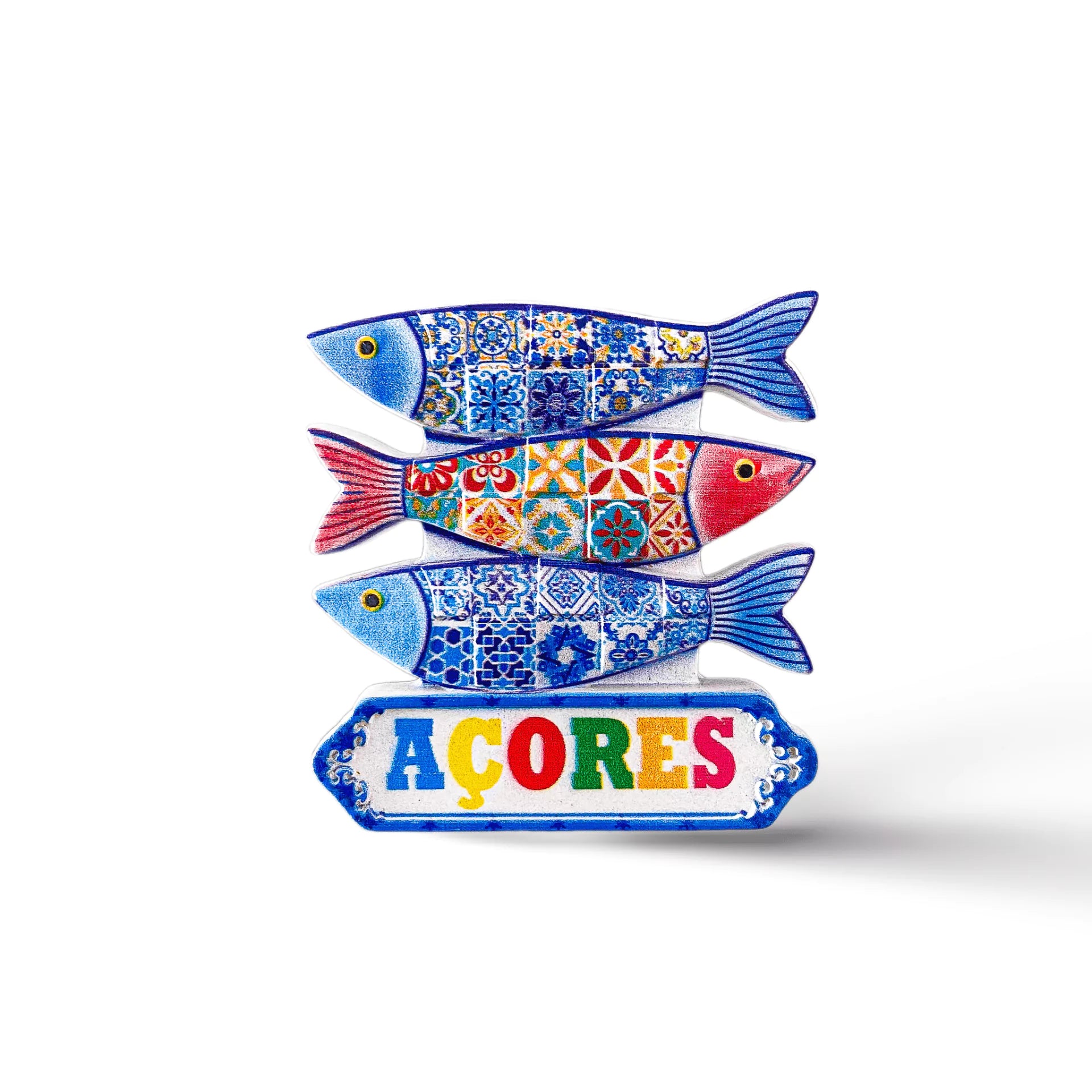 Ceramic artwork featuring three colorful fish with intricate patterns, styled in blue, red, and yellow. Below the fish, a sign reads "AÇORES" in vibrant letters. This charming Portugal souvenir magnet stands out against a plain white background.