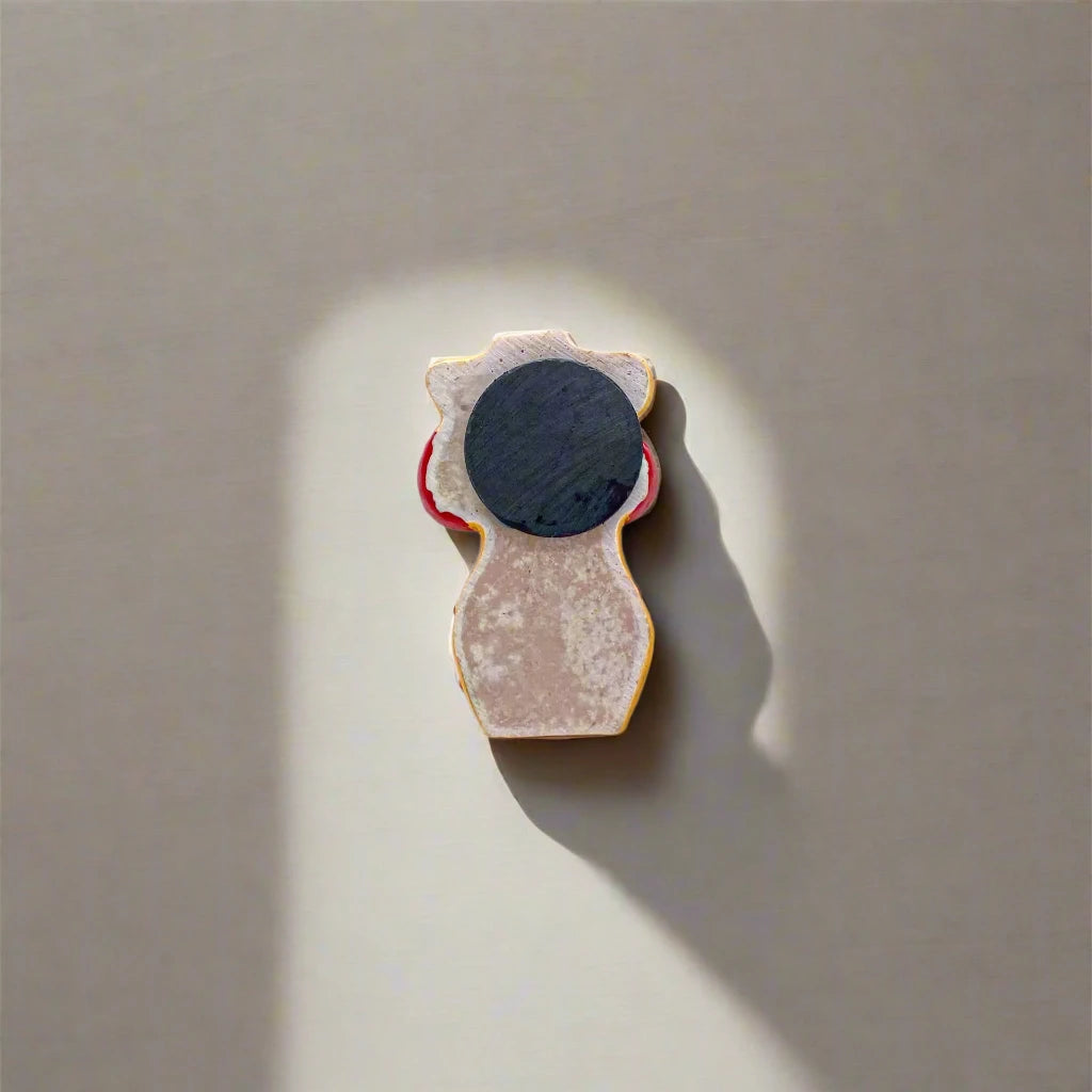 A small magnet shaped like a torso wearing a red polka dot bikini. The word "Lisboa" is printed on the bottoms alongside a flag emblem, paying tribute to Lisbon. The bright colors are highlighted against the white background.
