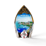 Souvenir magnet shaped like a boat with "MADEIRA" at the top. This charming keepsake features a scenic view of Madeira with blue waters, boats, cliffside houses, and a lifebuoy at the bottom. Perfect for any magnet collection or as a nostalgic reminder of your trip to this beautiful island.