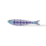 A ceramic sardine figurine with a blue and white intricate pattern, reminiscent of traditional Portuguese tiles. The fish's head is blue with a yellow eye, and the pattern runs along its body, segmented into four parts. The word "Portugal" is visible near the tail, making it a perfect souvenir.