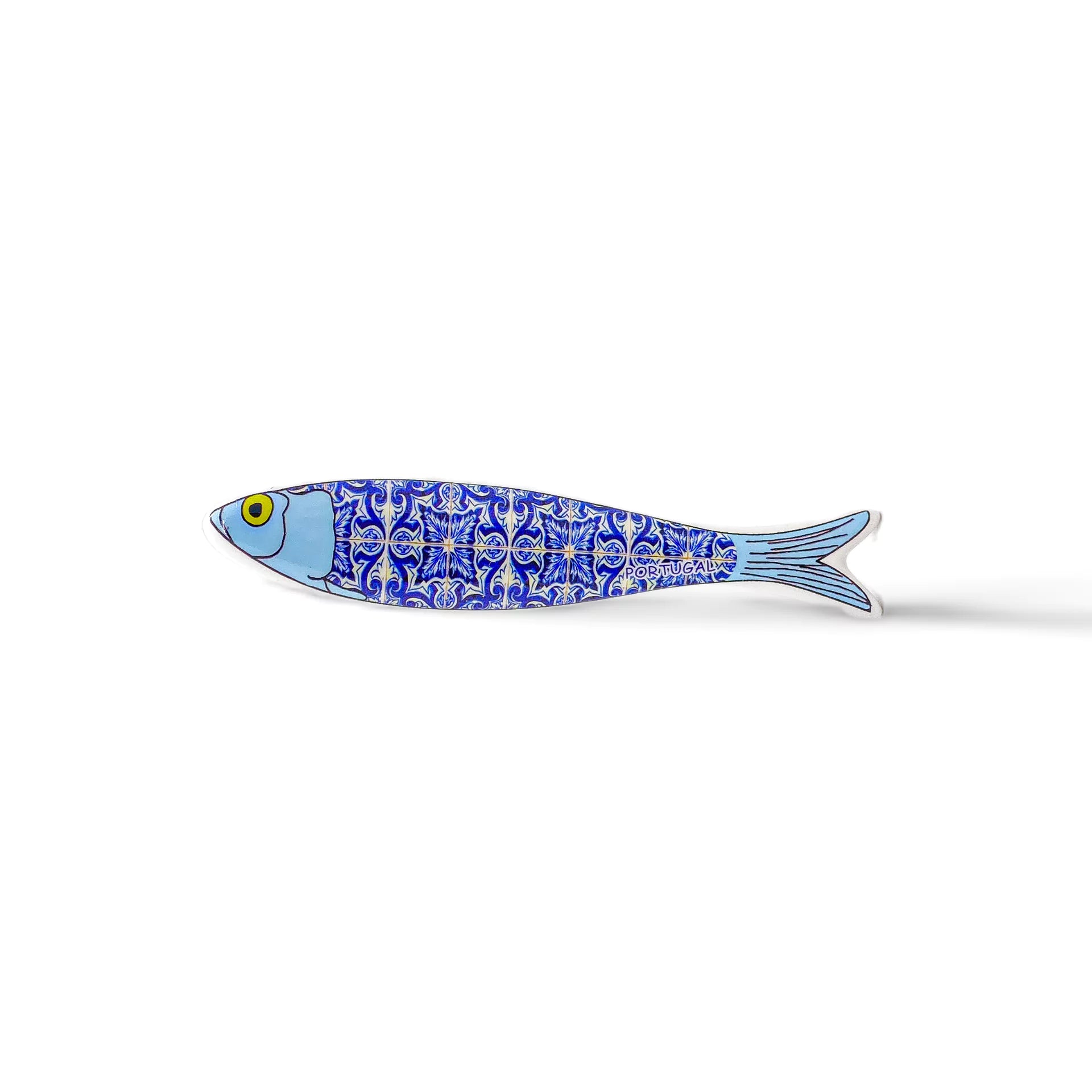 A ceramic sardine-shaped plate with a blue and white intricate pattern reminiscent of traditional Portuguese tile designs. The fish's face and tail are plain blue, while the body is decorated with the patterned tiles. This charming piece makes a perfect Portugal-themed souvenir, set against a white background.