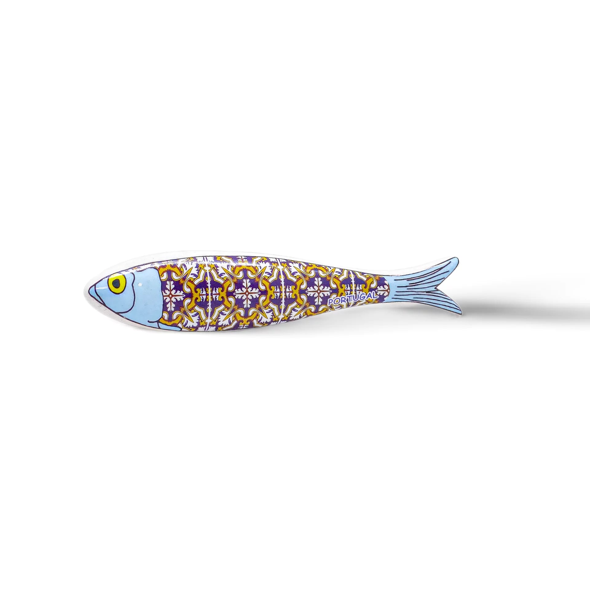 A stylized fish sculpture, resembling a Portugal sardine, features a blue head and an intricately patterned body in yellow, white, and purple. With a single large yellow eye and a light blue tail that fades into the background, this vibrant design doubles as an exquisite magnet.