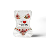 A curvy hourglass-shaped shot glass souvenir features the text "I ❤️ PORTUGAL" surrounded by images of pink flamingos and red flowers. The design is colorful and vibrant, showcasing the love for Portugal.