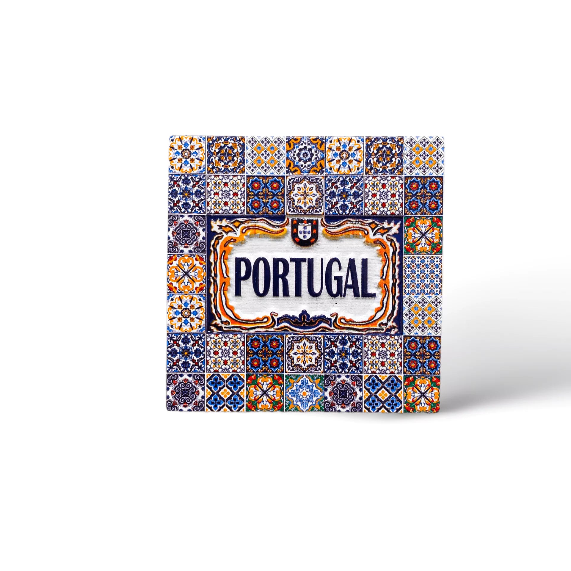 A decorative ceramic tile magnet featuring intricate, colorful patterns with the word "Portugal" centered in bold blue letters and framed with ornate yellow and blue designs. This exquisite piece showcases traditional Portuguese azulejos art style, making it a perfect souvenir from Portugal.
