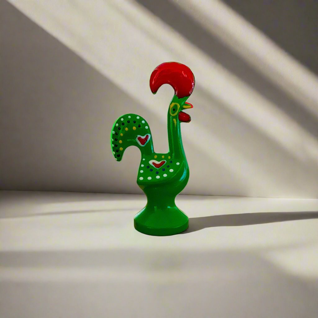 A colorful green and red rooster figurine, representing the Galo de Barcelos, placed on a clean white background.
