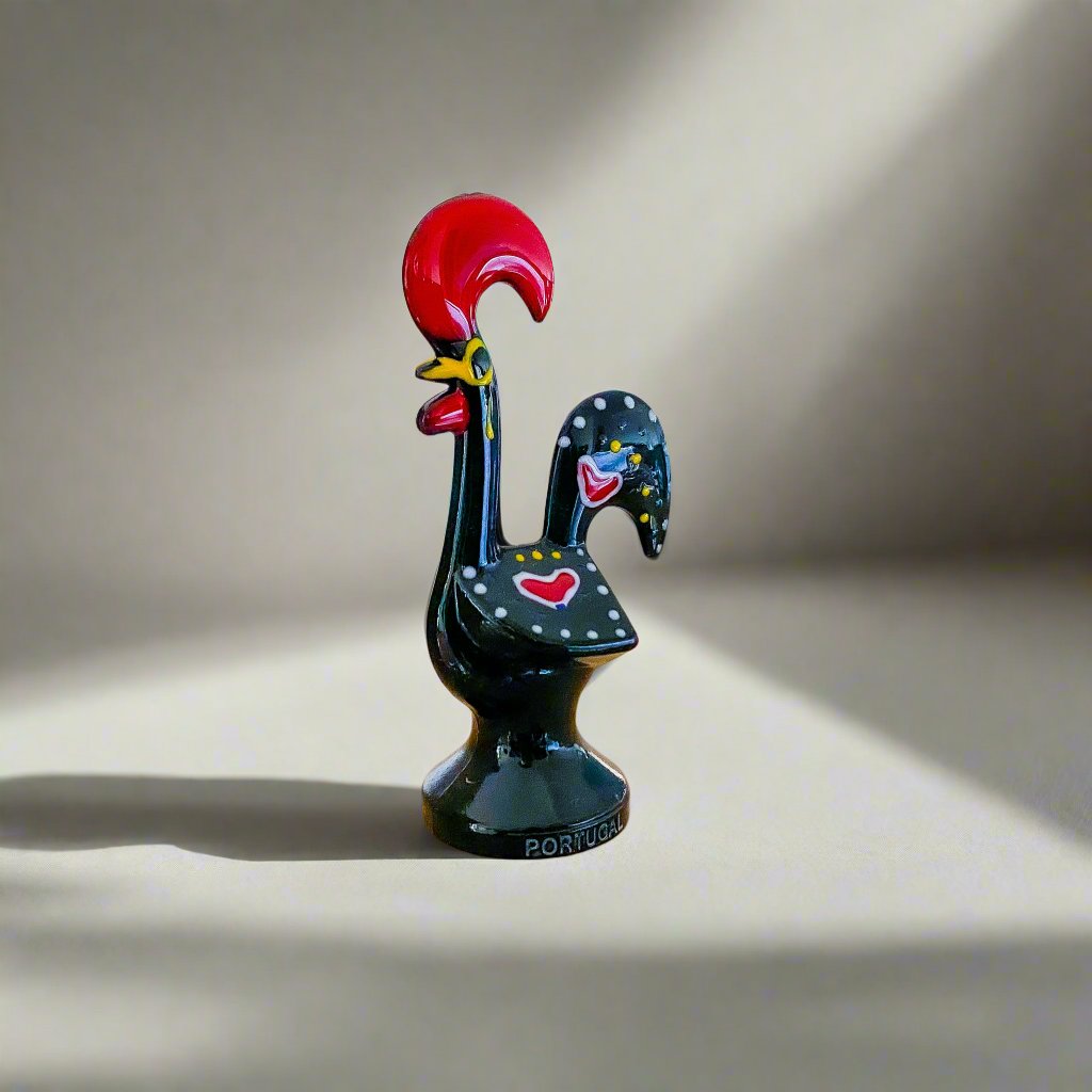 A black and red rooster figurine, a traditional Galo de Barcelos souvenir from Portugal, elegantly positioned on a table.