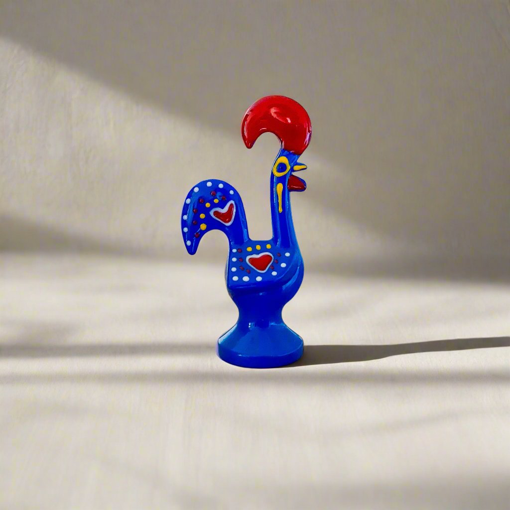 A vibrant blue and red rooster figurine, symbolizing the Galo de Barcelos, a popular Portuguese souvenir.