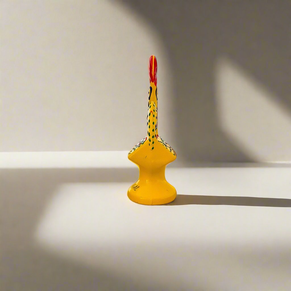 A cheerful yellow ceramic rooster, representing the Galo de Barcelos, a traditional souvenir from Portugal.