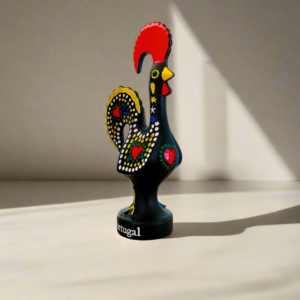 A black rooster figurine embellished with red and yellow feathers, representing the iconic Galo de Barcelos from Portugal.