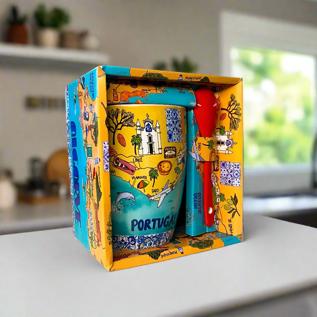 Colorful mug with 'Portugal' text in a decorative box on a desk.