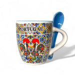 Colorful mug with 'Portugal' text and rooster design, featuring a blue spoon on a white background.