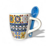 Decorative mug with colorful patterns and a blue spoon on a white background