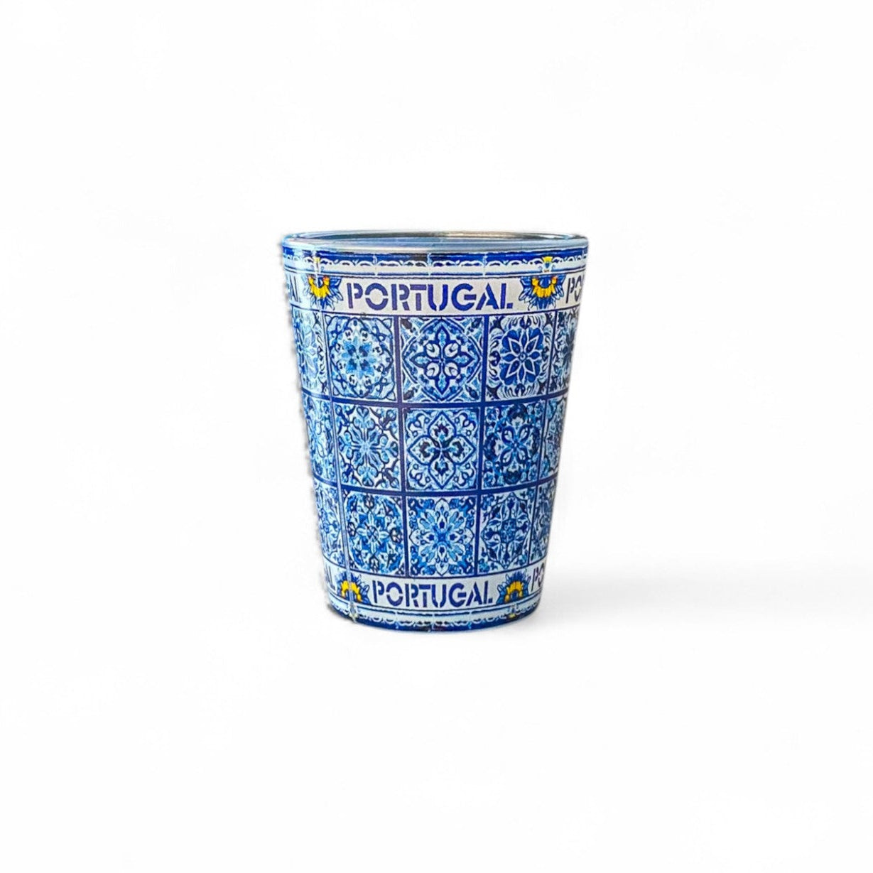 A shot glass with traditional blue azulejo tile pattern and the text 'PORTUGAL' on the side.
