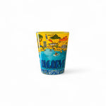 A shot glass with a colorful illustrated map of the Algarve region on a white background.