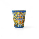 A shot glass with a colorful traditional Azulejo mosaic tile design and the word 'Portugal' printed on it.