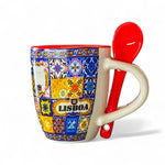 Colorful coffee cup with decorative patterns and a red spoon on a white background