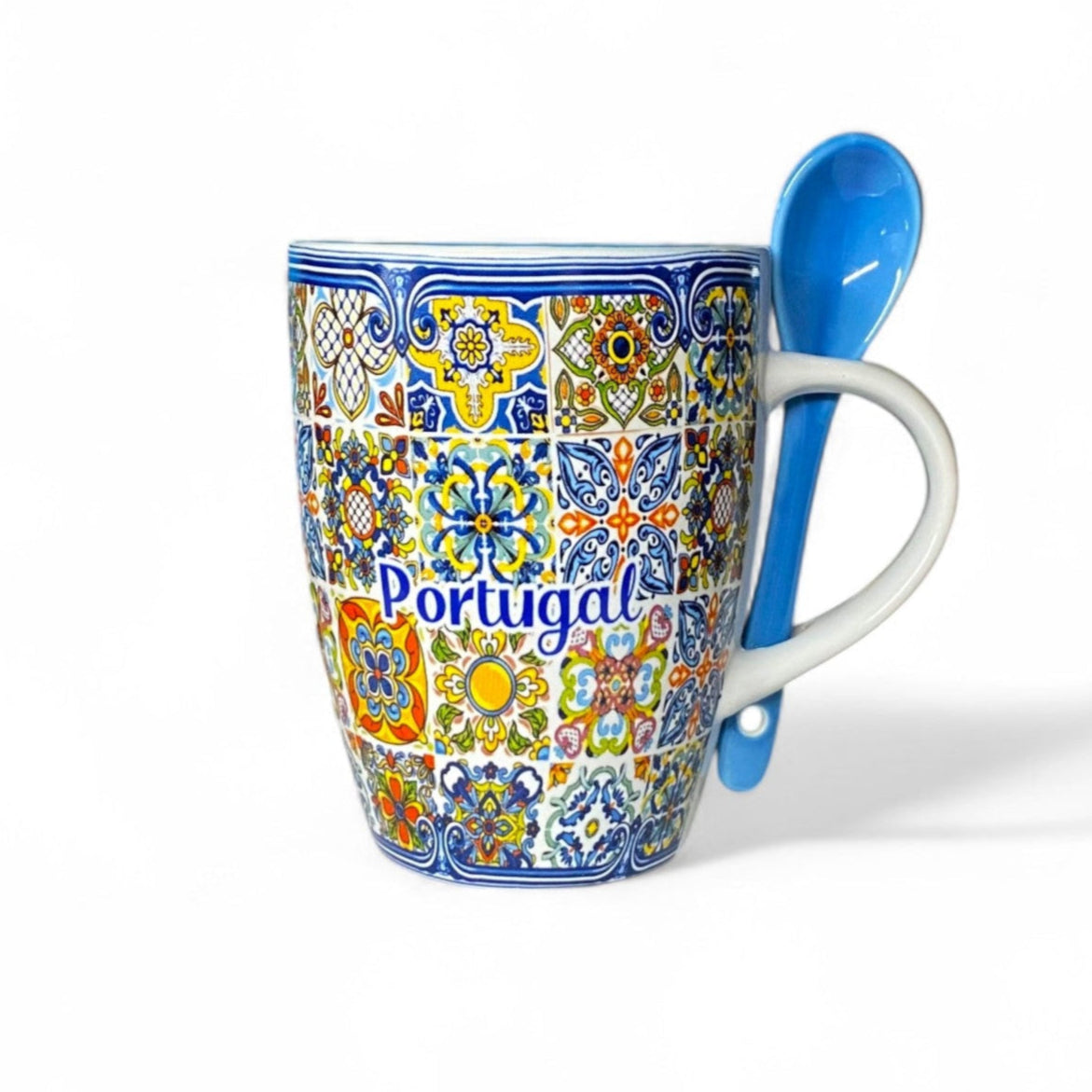 A colorful ceramic souvenir mug with a 'Portugal' text on it, featuring a traditional multicolored azulejo tile pattern, accompanied by a blue ceramic spoon. The mug is displayed against a white background.