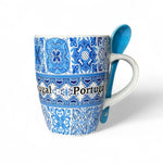 A blue and white ceramic mug with a striped tile design and the word 'Portugal' written on it, accompanied by a matching blue spoon, displayed against a white background.