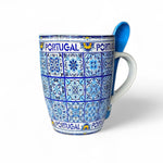 A ceramic souvenir mug with a blue azulejo tile pattern, accompanied by a ceramic spoon, displayed against a white background.