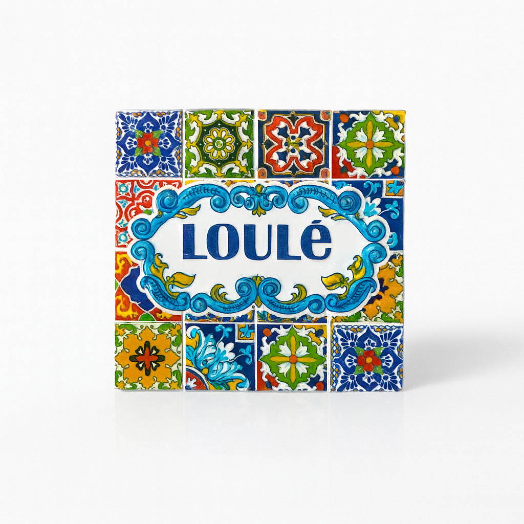 Square resin magnet with the word “Loulé” in blue, framed by an ornate scroll design and surrounded by multicolored traditional Portuguese azulejo tile patterns