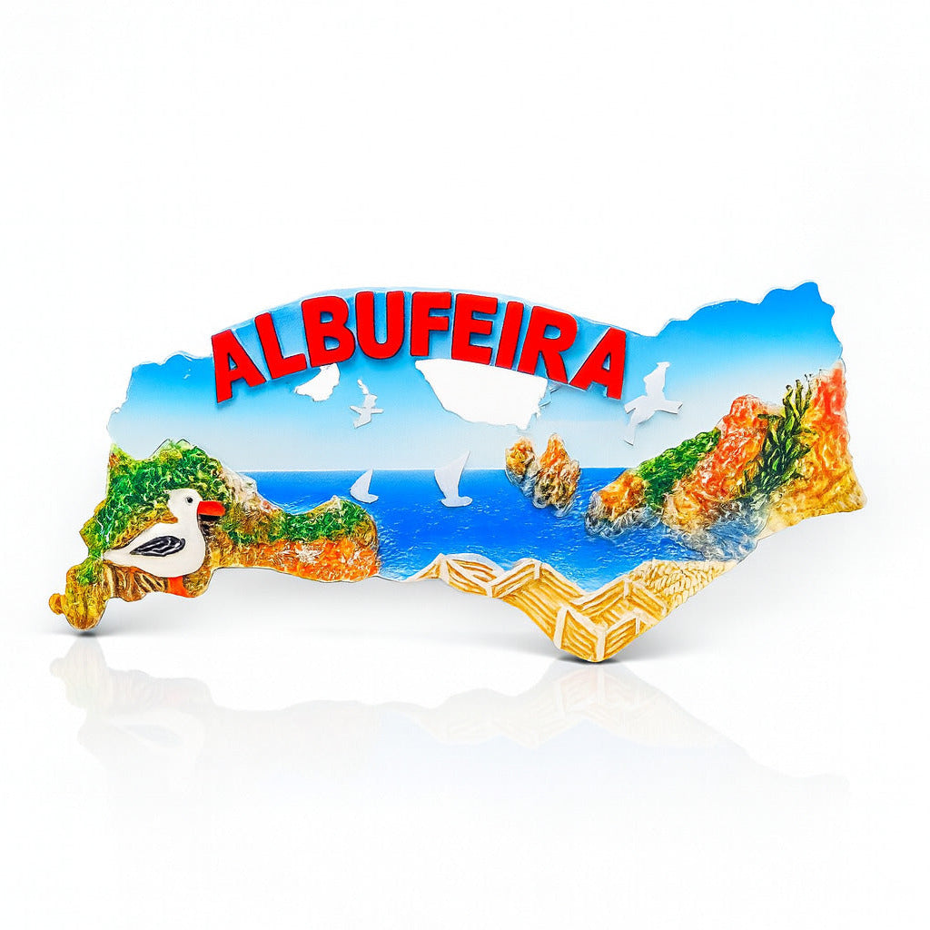 A colorful refrigerator magnet in the shape of Albufeira, featuring the coastal cliffs, seagulls, and a stork.