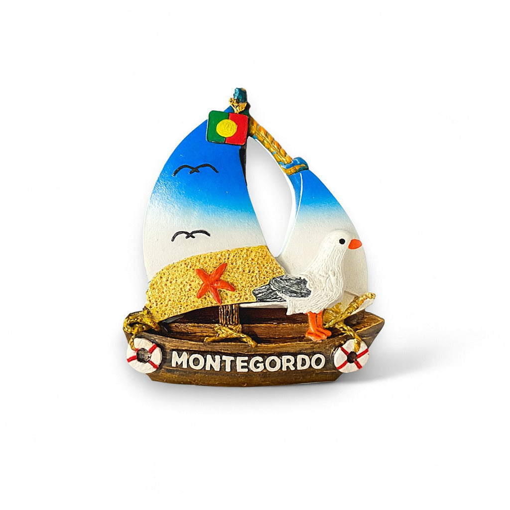 A colorful fridge magnet shaped like a sailboat with beach and seagull elements, and the text 'Monte Gordo' displayed.