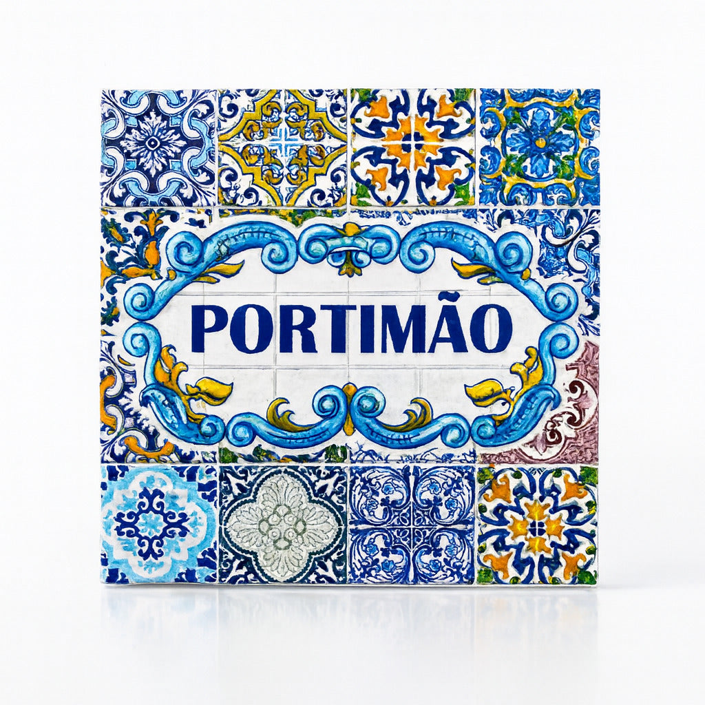A square Portuguese ceramic tile with intricate blue, yellow, and white patterns. The center features the name "PORTIMÃO" in bold blue letters, surrounded by floral and geometric designs. The tile, reflecting the traditional Azulejo style of Portugal's Algarve region, is a beautiful piece of craftsmanship.