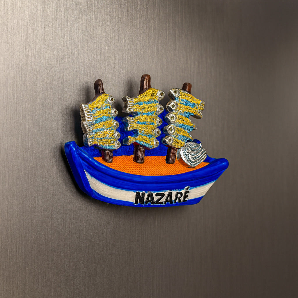 Fridge magnet shaped like a boat with 'Nazáre' on a metallic surface