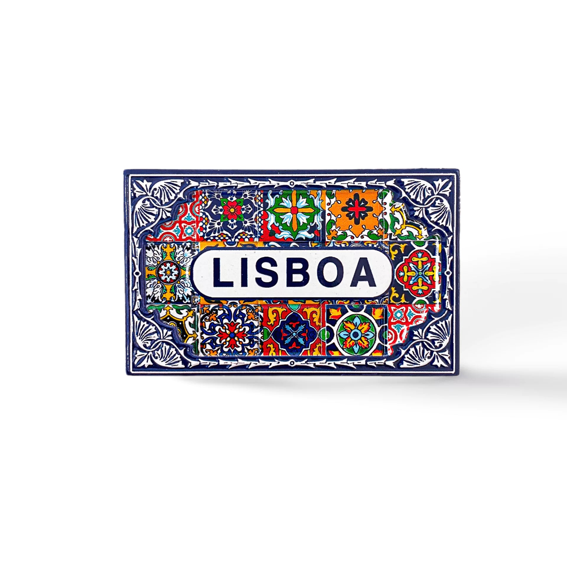 A rectangular ceramic tile with brightly colored geometric and floral patterns, predominantly in blue, red, yellow, and green. The center features the word "LISBOA" in bold blue letters on a white background, surrounded by intricate decorative designs. Perfect as a Lisbon souvenir magnet.