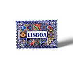 A colorful, rectangular magnet with intricate, traditional Portuguese patterns in blue, red, yellow, and green. The center prominently features the text "LISBOA" in blue on a white background. This Lisbon souvenir resembles a postage stamp with a serrated edge.