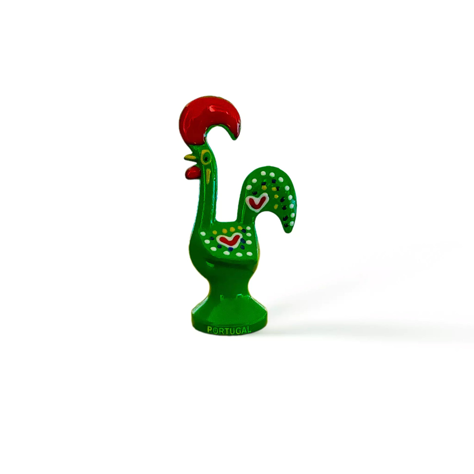 A vibrant green and red rooster figurine, a Galo de Barcelos souvenir, displayed on a white surface.
