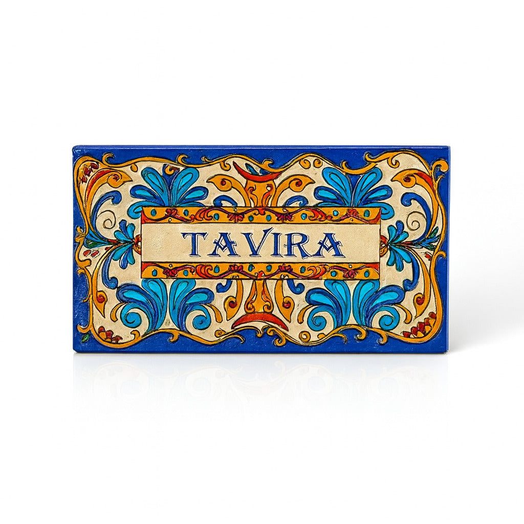 A rectangular fridge magnet featuring a colorful ornamental design with the text 'TAVIRA' in the center, on a blue background.