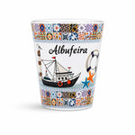 Studio image of Albufeira souvenir shot glass decorated with colorful Portuguese azulejo tiles, fishing boat illustrations, and Algarve coastal symbols