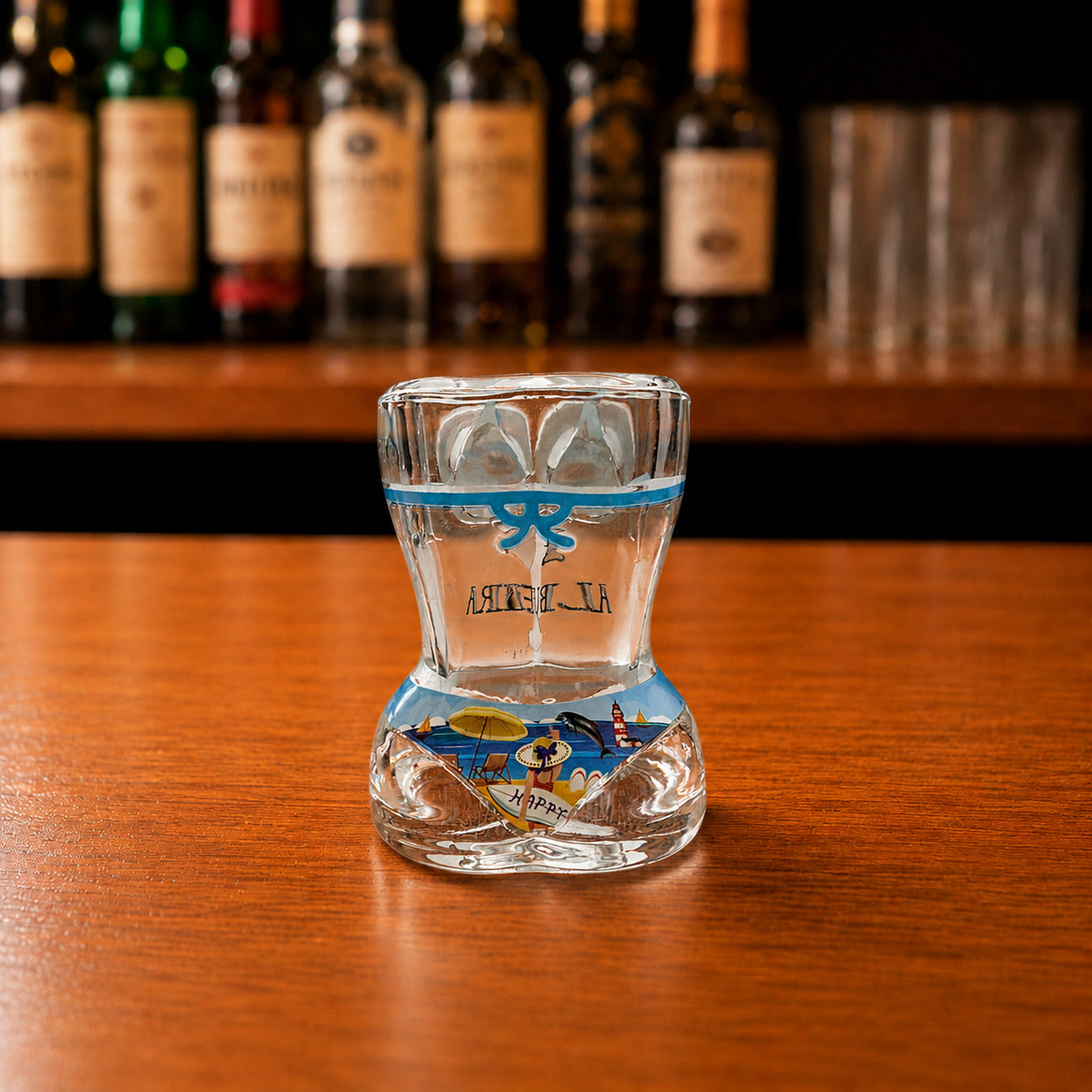 Back view of Albufeira women bikini style shot glass with blue beach-themed artwork including palm trees, anchor, seashells, and summer coastal illustrations.