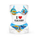 Transparent Albufeira souvenir shot glass with colorful bikini beach design, dolphins, lighthouse illustrations, and I Love Albufeira text on white background.