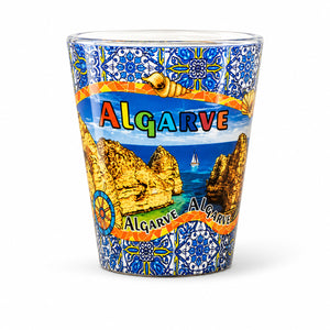Algarve Portugal souvenir shot glass with coastal landscape illustration, blue Portuguese azulejo patterns, and ocean scenery isolated on white background.