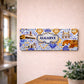 Algarve metal souvenir sign mounted on a wall displaying lighthouse, cliffs and traditional Portuguese tile patterns