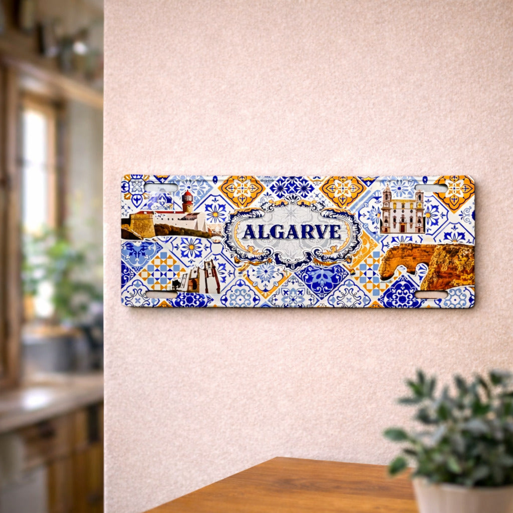 Algarve metal souvenir sign mounted on a wall displaying lighthouse, cliffs and traditional Portuguese tile patterns