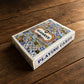 Algarve souvenir playing cards box displayed on a wooden table, with colourful Portuguese tile artwork and playing cards text on the side.