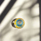 Top view of Algarve Portugal souvenir shot glass featuring colorful illustrated map artwork with soft natural shadows.