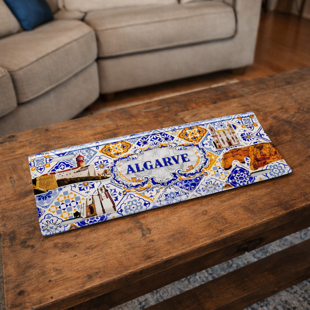 Algarve metal souvenir sign placed on a wooden table featuring coastal scenery and classic Portuguese azulejos design