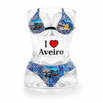Transparent Aveiro souvenir shot glass featuring women bikini design with blue azulejo patterns, moliceiro boats, colorful Aveiro houses, and I Love Aveiro print on white background.