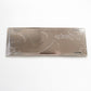 Backside of Aveiro metal souvenir sign showing engraved outlines of boats and buildings on a metallic surface