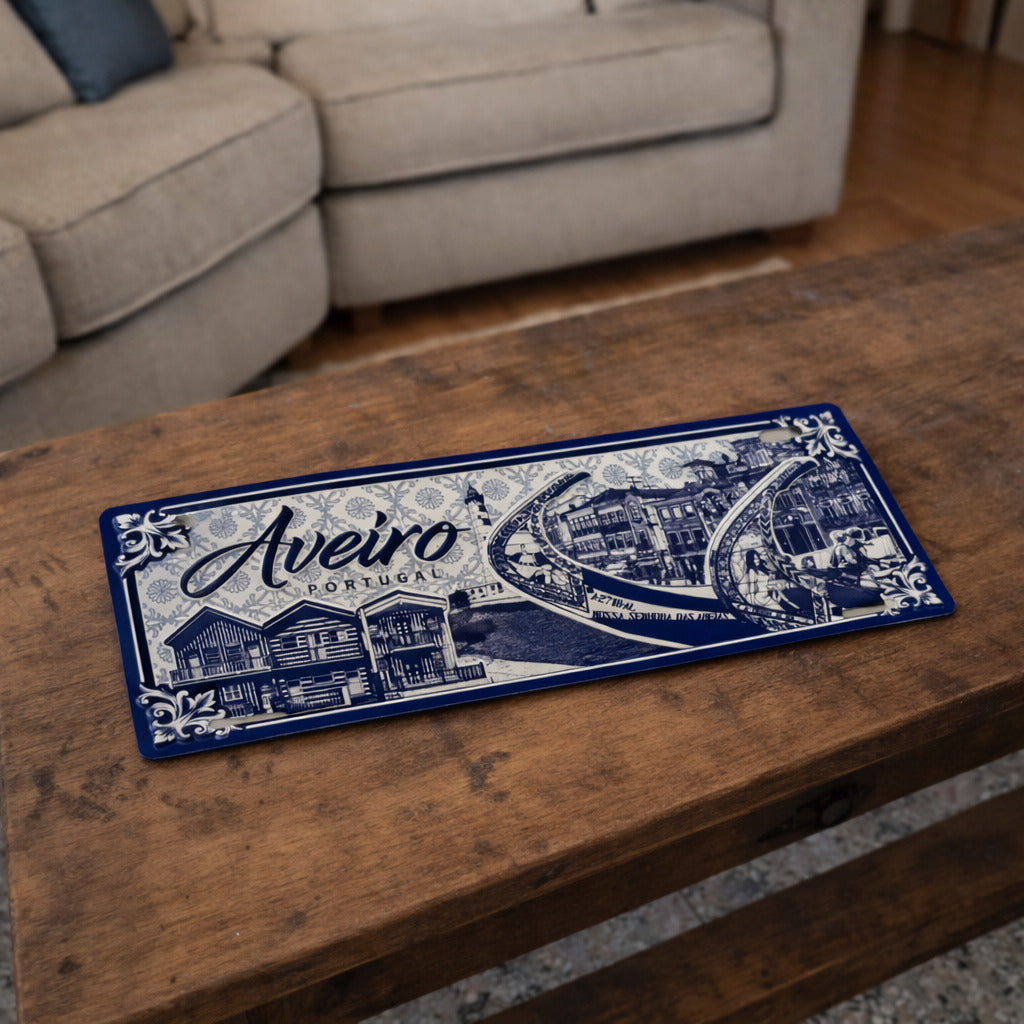 Aveiro metal souvenir sign placed on a wooden table showing moliceiro boats, coastal buildings and classic Portuguese tile patterns