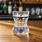 Back view of Aveiro women bikini style shot glass with black decorative stripe and traditional Portuguese azulejo inspired artwork displayed on wooden surface.