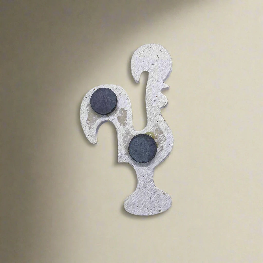 Decorative ceramic rooster, known as the Rooster of Barcelos, a symbol of Portuguese heritage. It features colorful red details on the comb, wattle, and heart patterns on its white body, with "Portugal" on the blue base. Ideal as a decorative magnet.