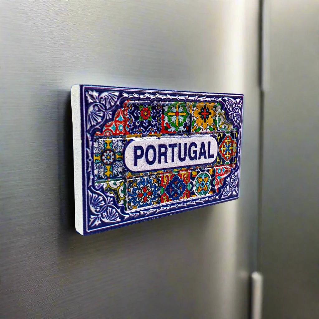 A decorative tile magnet featuring the word "PORTUGAL" in the center, surrounded by intricate floral and geometric patterns in bold colors, including red, blue, green, yellow, and white. This vibrant piece makes for a beautiful souvenir.