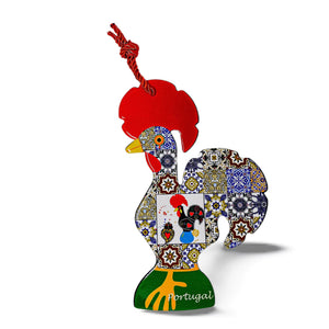A colorful wooden Barcelos rooster ornament with a red comb and intricate mosaic designs featuring traditional Portuguese motifs. The rooster has a red string loop for hanging and the word "Portugal" is written near its base, making it the perfect souvenir.