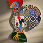 This colorful wooden Barcelos rooster features a red comb and intricate mosaic designs inspired by traditional Portuguese art. With a red hanging loop and "Portugal" inscribed near the base, it's the perfect keepsake.